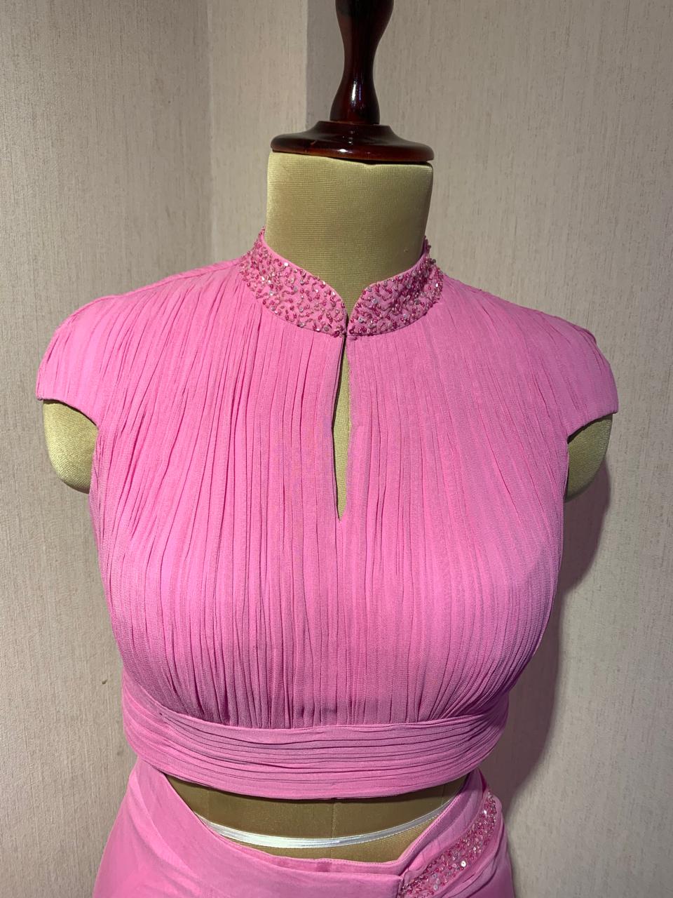 PINK GEORGETTE DRAPED SAREE WITH PLEATED HIGH NECK BLOUSE.