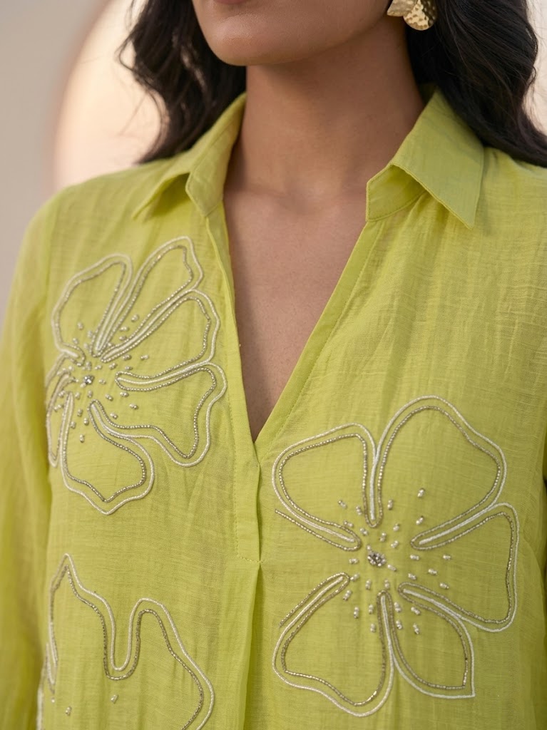 ELEGANT GREEN FLARED DRESS FEATURING DELICATE FLORAL EMBROIDERY.