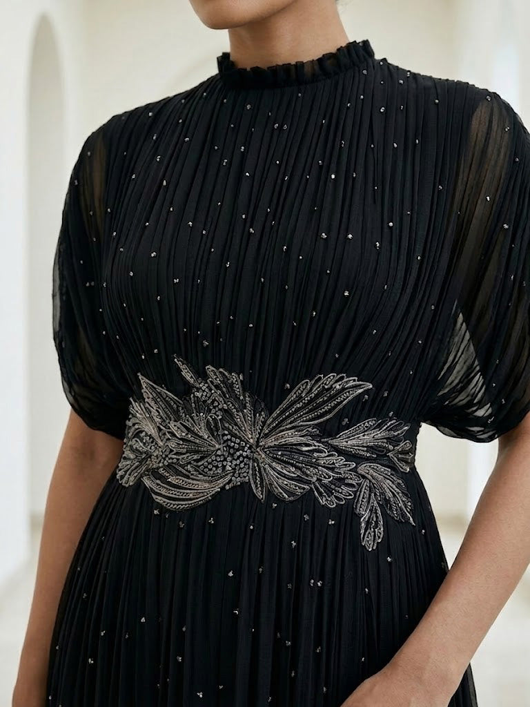 BLACK SEQUIN AND WIRE EMBELLISHED PLEATED GOWN WITH SHEER SLEEVES.